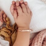 Commemorate your little one's arrival with a personalized baby name plate bracelet. Crafted in hypoallergenic metals like sterling silver or gold, these delicate bracelets feature custom engravings of your child's name,