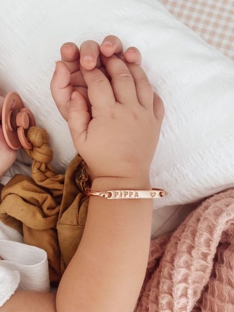 Commemorate your little one's arrival with a personalized baby name plate bracelet. Crafted in hypoallergenic metals like sterling silver or gold, these delicate bracelets feature custom engravings of your child's name,